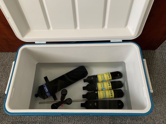 A photo of a cooler partially filled with water, and four aquaMeasure DOT sensors, three HOBO sensors, and one VR2AR sensor submerged. 